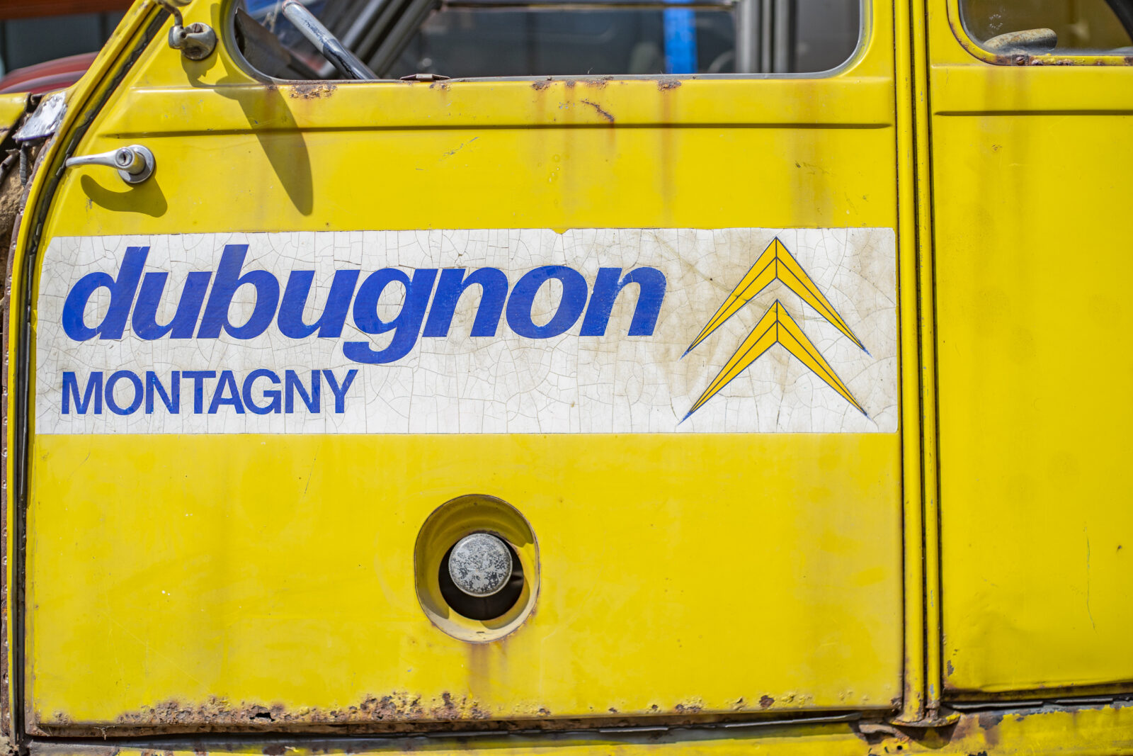 Citroën 2cv 4x4 Sahara in the color jaune service - view of the left door with Citroën logo of Dubugnon Montagny